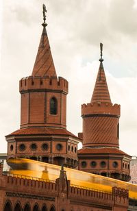 Low angle view of train moving on oberbaum bridge against sky