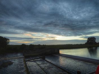 View of calm lake against cloudy sky