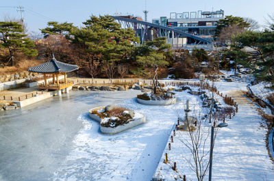 View of frozen lake in city during winter