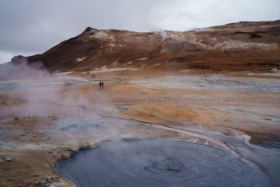 Smoke emitting from volcanic geyser against sky