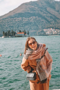 Portrait of smiling woman standing in sea