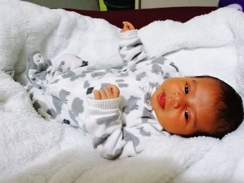 High angle view of baby lying on bed