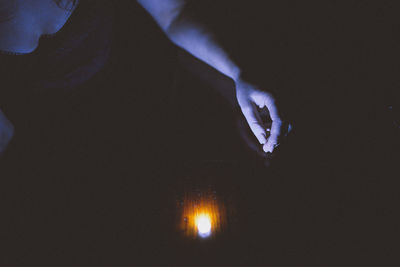 Close-up of human hand against illuminated light