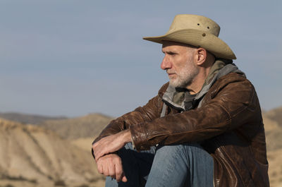 Adult man in cowboy hat looking at view of tabernas desert, almeria, spain