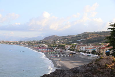 High angle view of townscape by sea against sky