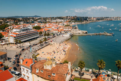 High angle view of townscape by sea against sky