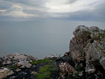 Rocks by sea against sky