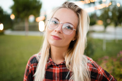 Smiling beautiful young adult student female girl wear glasses over glow lights 