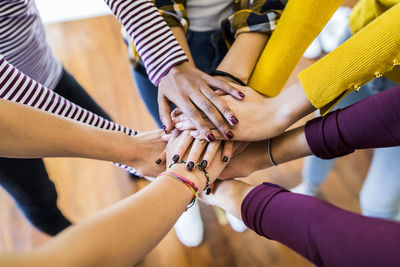 Close-up of five women stacking their hands