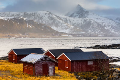 Scenic view of sea by snowcapped mountains against sky