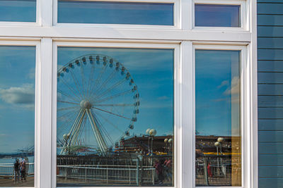 Low angle view of ferris wheel against buildings in city