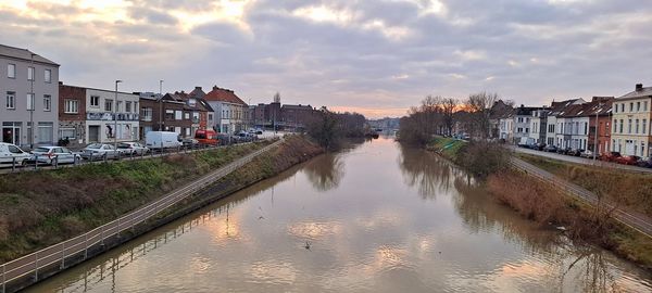 Canal amidst buildings against sky