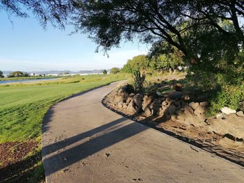 Road amidst field against sky