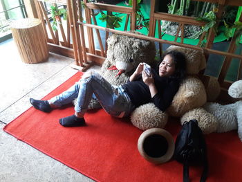 Full length of young woman sitting on floor at home