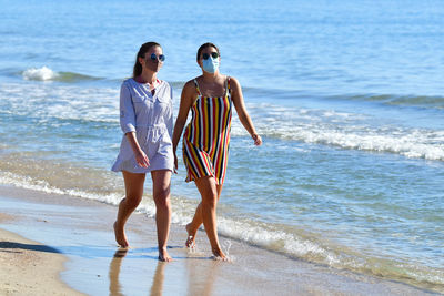 Rear view of women standing on beach