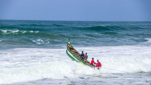 People in boat on sea against sky