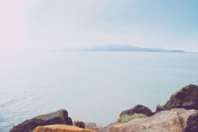 Scenic view of sea and mountains against sky