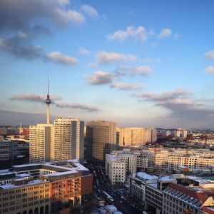 View of cityscape against cloudy sky