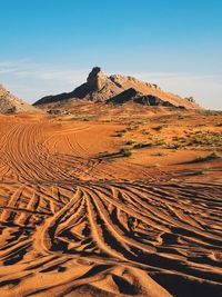 Scenic view of desert against clear blue sky