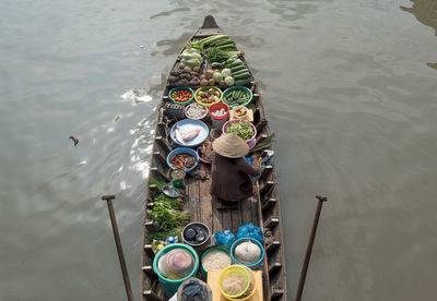 High angle view of person selling fruits and vegetables on boat in river