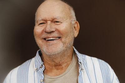 Happy senior man looking away in studio