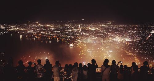 People looking at illuminated cityscape