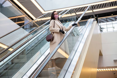 Low angle view of woman on escalator