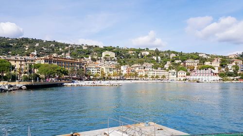 View of townscape by sea against sky