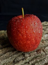 Close-up of wet apple against black background