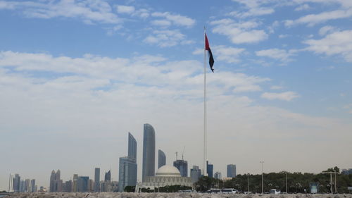 Low angle view of skyscrapers against cloudy sky