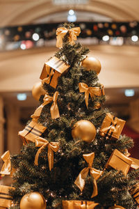 Christmas tree decorated with golden gift boxes and christmas balls. magic cozy details