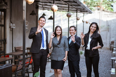 Business colleagues standing against wall