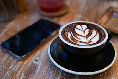 A coffee cup placed on a wooden table