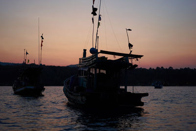 Silhouette ship in sea against sky during sunset