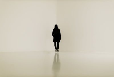 Rear view of woman standing against white background