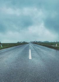 Empty road against cloudy sky