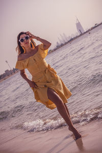 Woman wearing sunglasses standing at beach