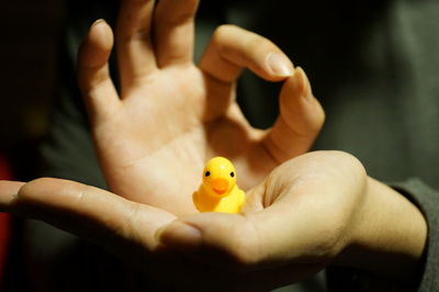 Close-up of hand holding yellow toy