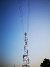 Low angle view of electricity pylon against clear sky