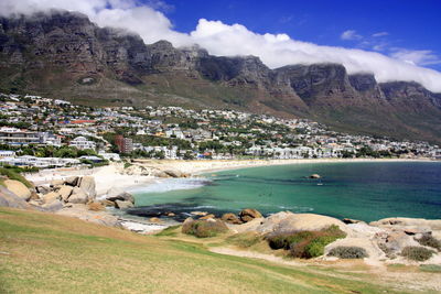 Scenic view of sea by buildings against sky