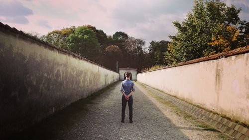 Rear view of man walking on country road