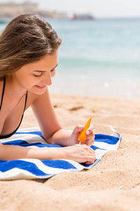 Woman lying on sand at beach