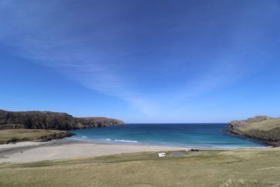 Scenic view of beach against blue sky