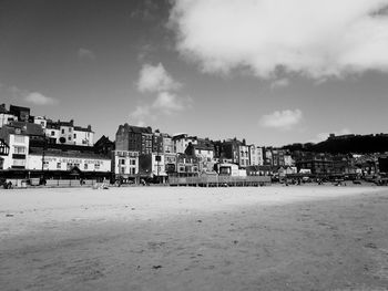 Houses by sea against sky in city