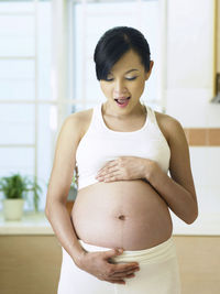 Side view of pregnant woman at home