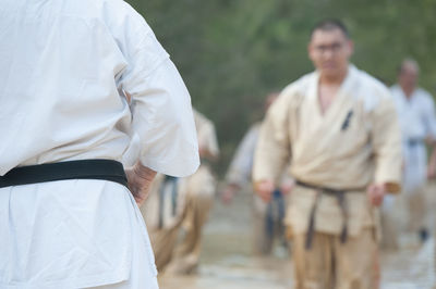 Midsection of man teaching karate to students