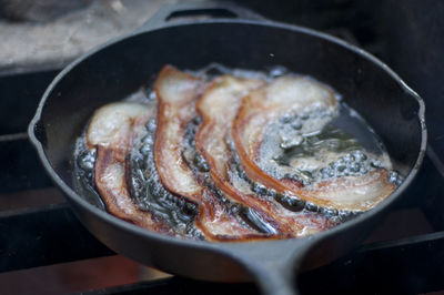 Close-up of bacon frying in pan