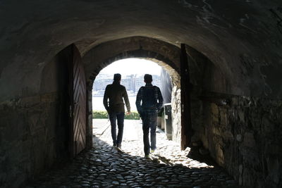 Rear view of man walking in tunnel