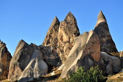 Low angle view of rock formation against clear blue sky