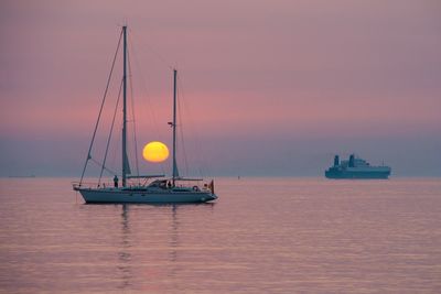 Boat on sea against sky during sunset